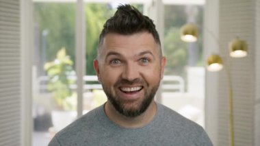 Yakından bakınca şapşal adam eğleniyor. Çizgi roman mankeni şaşı gözlerle dalga geçiyor. Kapalı alanda kamerada yakışıklı bir yüz ifadesi. Portre sanatçısı modern apartmanın arka planında komik suratlar yapıyor.