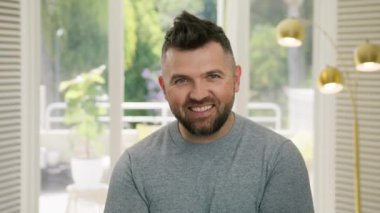 Portre sanatçısı modern apartman arka planında komik suratlar yapıyor. Kapalı alanda kamerada yakışıklı bir yüz ifadesi. Yakından bakınca şapşal adam eğleniyor. Çizgi roman mankeni kaşlarını kaldırıyor.