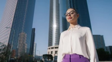 Gülümseyen genç bayan profesyonel yönetici iş ortağının ya da müşterinin arka plandaki modern ofis binalarıyla iş anlaşması yaparken elini sıkıyor. Mutlu işveren yeni bir iş buldu.
