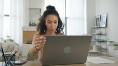 Genç Afro-Amerikan odaklı kadın yönetici yönetici iş kadını ofis masasında oturuyor. Dizüstü bilgisayarda farklı renkte yazı yazan, çağdaş evde bilgisayar üzerinde çalışan bir kadın. İş kadını.