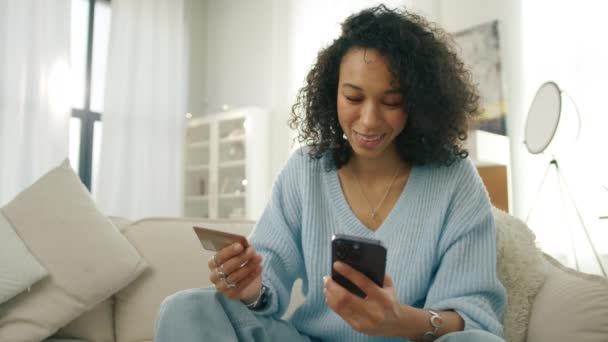Leende Ung Multietnisk Kvinna Tittar Kreditkort Skriva Personuppgifter Smartphone Pekskärm — Stockvideo