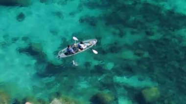 Yaz gezisi. Her yere git. Açık hava spor aktivitesi. Mavi Tahoe Gölü 'nün yanındaki turne sırasında, mutlu turistler temiz kano üzerinde kürek çekiyorlar. Güzel şeffaf mavi suları olan dağ gölü manzarası.