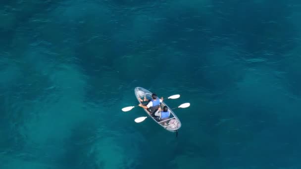 在游览美丽的蓝色塔荷湖的过程中 快乐的年轻女子和男子在清澈的皮划艇上划桨 高山湖泊的空中景观 蓝水清澈秀丽 夏天的旅行去任何地方 户外运动 — 图库视频影像