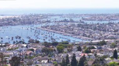 Balboa Adası, Newport Sahili, Kaliforniya, Batı Sahili, ABD 'deki panoramik yerleşim evleri ve marina manzarası. Pasifik Okyanusu tarafından yıkanan Balboa yarımadasının insansız hava aracı çekimi. Kendi plajı olan lüks villalar.