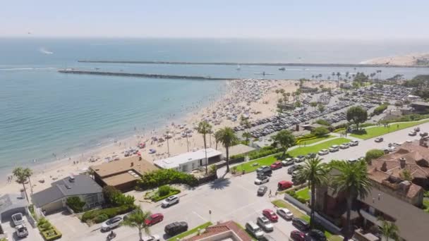 在美国加州新港海滩 西海岸的科罗纳德尔马海滩上 有很多人在放松自己 俯瞰新港湾的居民住宅 夏季海洋景观 4K镜头 — 图库视频影像