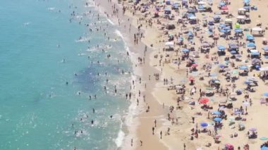 İnsansız hava aracı, Corona Del Mar, Newport Beach, California, batı sahili, ABD sahillerinde güneşlenen kalabalığın üzerinde uçuyor. Newport Körfezi turistlerle dolu. İnsanlar tatilde plajda dinleniyorlar. 