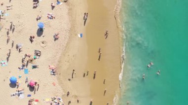 Pasifik Okyanusu, Laguna Sahili, Orange County, Kaliforniya, ABD 'deki kumlu sahilde yüzen insanların en iyi görüntüsü. Turistlerin yaz tatilinin tadını çıkardıkları drone görüntüleri. Okyanusun kristal yeşil suyu, 4k görüntü