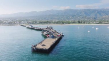 Stearns Wharf ve Santa Barbara limanının dağları, Kaliforniya, ABD ile hava manzarası. Eski tahta iskelenin popüler turistik cazibesinin panoramik çekimi. Pasifik Okyanusu kıyısında yüzen yat ve tekneler