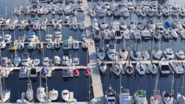 Santa Barbara Limanı, Kaliforniya, ABD 'deki lüks yatların havadan görüntüsü. Marinadaki Point Castillo 'dan teknelerle vurulmuş. Rıhtımda birlikte koşan çocukların robot resmi, 4K görüntü.