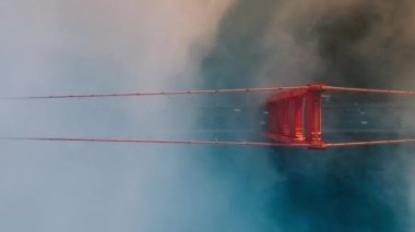 Kırmızı Golden Gate köprüsünün etrafında sürüklenen dramatik turuncu bulutlar oluşturuluyor. Golden Gate Köprüsü 'nde yoldan geçen arabaların dikey antenleri. San Fransisco 'nun Amerika' daki tarihi görüntüleri.