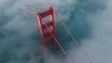 San Francisco 'daki Golden Gate Köprüsü' nün kırmızı kulesinde sürüklenen dramatik mavi deniz mavisi sis bulutu görüntüsü oluşturuluyor. Amerikan sınır işaretli uzun kırmızı Golden Gate Köprüsü İnşaat Günbatımı ABD 4K