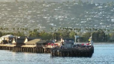 Santa Barbara, California, ABD. Ekim 06, 2023: İnsanlar Stearns Wharf, Santa Barbara, Kaliforniya, ABD 'yi ziyaret ediyor. Meşhur seyahat yeri. Dağ tepelerindeki şehir binaları, 4k görüntü 
