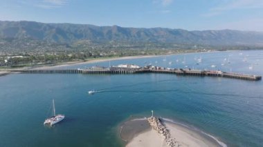 Santa Barbara kıyılarının panoramik manzarası ve Stearns Wharf, California, ABD. Castillo Noktası 'ndan, yatlı, pitoresk limana insansız hava aracı atışı. Dağların manzarası ve Pasifik kıyı şeridi, 4k görüntü