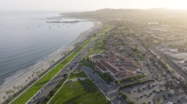 Günbatımında Santa Barbara şehrinin doğal manzarası, Kaliforniya, ABD. Pasifik Okyanusu 'ndaki tatil köyünün insansız hava aracı görüntüleri. Sahil boyunca yerleşim yerleri ve oteller, 4k görüntü 