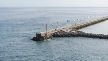 Santa Barbara Limanı 'ndaki Point Castillo' dan Kaliforniya, ABD 'deki iskelede yürüyen insanların görüntüsü. Turistin okyanus manzarasının keyfini çıkarırken çekilmiş bir fotoğrafı. Limana yanaşmış lüks yatlar ve tekneler, 4K görüntü.