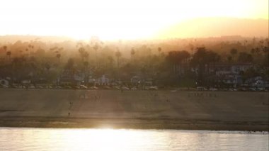 Santa Barbara 'nın günbatımındaki panoramik görüntüleri, Kaliforniya, ABD. Kumsalda yaz akşamının tadını çıkaran insanların robot resmi. Altın saatte inanılmaz bir şehir manzarası. Yaz konsepti, 4k çekim 