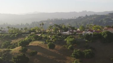Calabasas 'ın zengin toplumunun panoramik görüntüleri Santa Monica dağlarını, Los Angeles banliyösünü, Kaliforniya' yı çevreledi. Dağın tepesindeki lüks evler ve villaların insansız hava aracı görüntüsü, 4K görüntü.