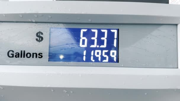 パトロールステーションのガス給油メーターの青いデジタルスクリーン ガロンとドルで燃料を量る ガソリン価格カウンター クローズアップ 燃料が車のタンクに入るにつれてスクリーン1ガロンあたりの価格の増加 — ストック動画