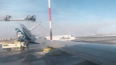 LOS ANGELES, CALIFORNIA, ABD-30 EKİM 2023: Westjet uçakları havaalanında buzdan arındırma tedavisi görüyor. Uçuştan önce uçaklarda anti-özgürlük tedavisi. Makine uçak kanadında krema önleyici sıvı püskürtüyor