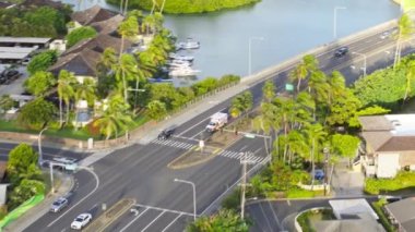 Yeşil Oahu adasında hızlı giden ambulans aracı. Neredeyse boş yolda sirenli bir acil servis arabası var. Hawaii 'deki küçük bir kasabada acil durum. Altın günbatımı ışığı 4K insansız hava aracı atışı, ABD