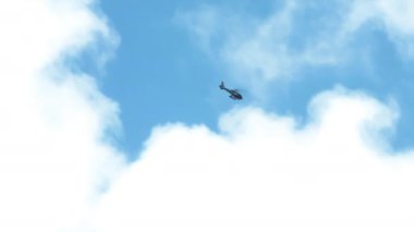 Mavi gökyüzünde bulutların içindeki helikopter görüntüsü. Oahu adası üzerinde helikopter turu. Havai manzarası bulutlu bir günde helikopterle uçan turistler. Manzaralı açık hava macera turu. ABD Turizmi 4K