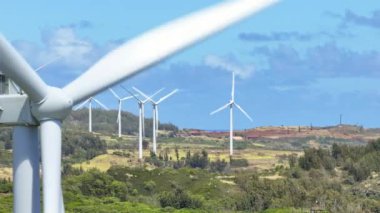 Hawaii 'de güneşli bir yaz gününde yel değirmenlerinin hava manzarası. Yenilenebilir enerji kavramı. Rüzgar enerjisi teknolojisi 4K. İklim değişikliği konsepti b roll USA. Tropik Oahu Adası 'ndaki sinematik rüzgar santrali.