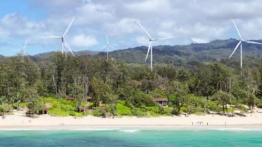 Hawaii sahillerindeki Oahu adasında rüzgar enerjisi. İklim değişikliği konsepti b roll. Tropik Oahu Adası 'ndaki sinematik rüzgar santrali. Güneşli yaz gününde yel değirmenlerinin hava manzarası. Yenilenebilir enerji 4K