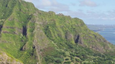Oahu Adası, Hawaii USA ekstrem sporu. Pilot gökyüzünde maceraperest ekstrem sporlar yapıyor. Pasifik Okyanusu kıyısındaki Hawaii yabanı üzerindeki hava sahili manzarası. Kualoa Çiftliği çekim yeri Bakış açısı