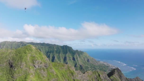 明るい夏の日に山とクァロア渓谷を飛行するパラグライダーの空中撮影 グリーン トロピカル ハワイアン山脈の壮大な景色 ブルースカイ4Kで息をのむような自然をパラグライダー — ストック動画