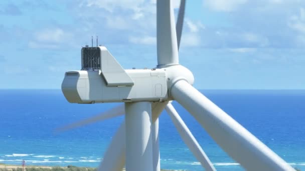 青い海に面した風車の回転ブレードのクローズアップビュー シネマティック風力発電所オアフ島 夏にウィンドミルズ空中 再生可能エネルギーコンセプト 気候変動対策コンセプト ハワイ アメリカ — ストック動画