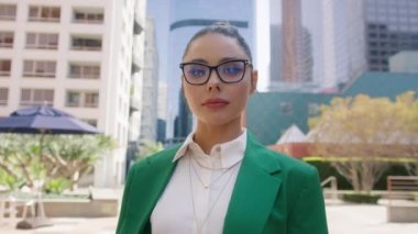 Profesyonel pazarlama müdürü, finansal danışman, idari lider, iş merkezinin önünde duran girişimci 4K. Kendine güvenen genç iş kadını açık havada portre çekimi için poz veriyor.