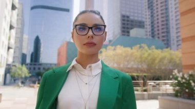 Kendine güvenen genç iş kadını açık havada vesikalık portre için poz veriyor. Profesyonel pazarlama müdürü, finans danışmanı, idari lider, iş merkezinin önünde duran girişimci 4K