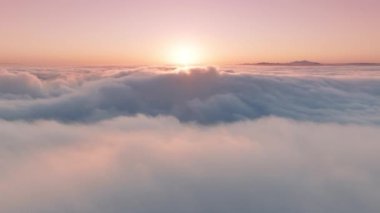 Gün doğumunda ya da günbatımında cennet bulutları üzerinde destansı hava manzarası. Yumuşak pastel rengi pembe, şeftali rengi ve açık mavi bulutlar altında hızla dönen harika ilham verici bir gökyüzü. Güzel bulutların üzerinde zaman akıp gidiyor