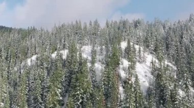Yüksek dağlarda güneşli bir günde hava turizmi. Kış tatillerinde arka planda fotokopi alanı olur. Donmuş kışın görüntüsü Dağ doğasında, mavi gökyüzünün altında. 4K