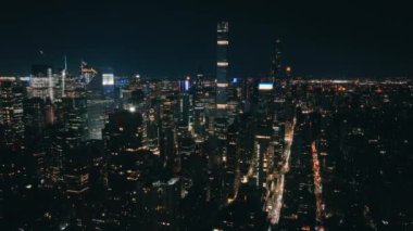 Modern gece şehrinin üstünde gerçek bir gece manzarası. Aydınlanmış Manhattan USA. New York şehrinin arka planı. Şehir merkezindeki Hava Saati Meydanı. Hava aracı karanlık çöktükten sonra gökdelenlerin üzerinde uçuyor.