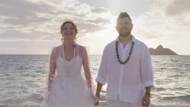 ランカイビーチで日没や日の出を楽しむハッピーロマンチックなカップル 新婚夫婦はまだ立って カメラを見ている オアフ島のハネムーン休暇 アメリカ旅行ライフスタイル — ストック動画