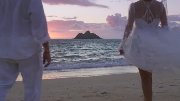 新娘和新郎穿着白色布荷风格的婚纱 准备在异国情调的岛上举行私奔仪式 一对恋人在沙滩上散步 享受热带夕阳西下的快乐时光 — 图库视频影像
