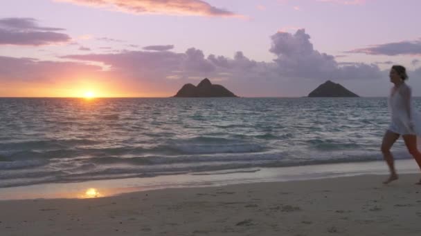 在夏威夷海滩上 一对快乐的年轻夫妇在日出时分跑到一起 新婚夫妇一起庆祝婚礼 两个人之间的爱蜜月旅行时 女孩和男人在日落时接吻 — 图库视频影像