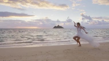 Gelinlikli mutlu genç kadın egzotik bir adada evlenmek için çıldırıyor. Heyecanlı bir gelin kumsalda dans ediyor, düğün gününü komik dans hareketleriyle kutluyor. Komik kahkaha 4K