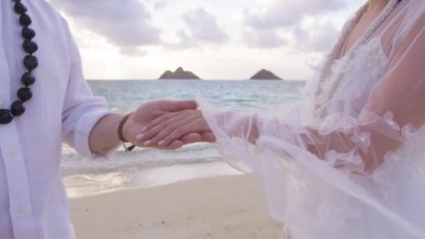 在海滩婚礼上 穿着白色布荷花婚纱的新郎新娘为结婚做准备 对男人和女人的浪漫的爱无法辨认的男人把戒指戴在女人的手指上 — 图库视频影像