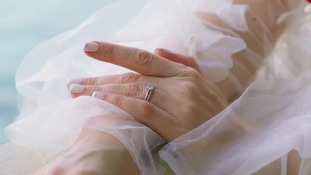 用漂亮的结婚戒指把新娘的手绑起来 婚礼上戴着钻石戒指的女性长手指 穿着白色长裙的女人看着结婚戒指 试戴钻石戒指的女人 — 图库视频影像