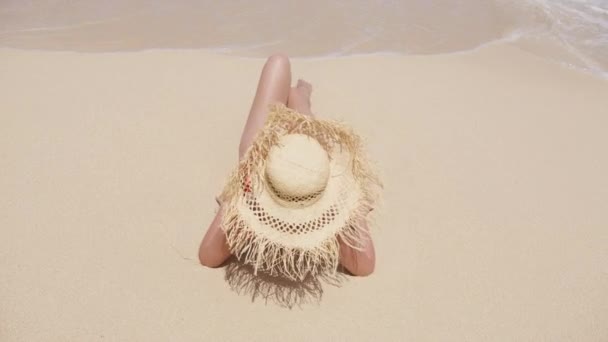 穿着红色泳衣 戴着夏帽的女人坐在海浪边潮湿的沙滩上的高角镜 梦幻般的风景尽收眼底 愉快的旅游度假记忆的概念 夏威夷岛背景 — 图库视频影像