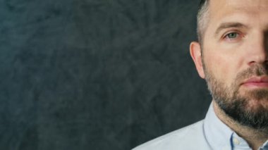 Yarı yüz portresini kapat yakışıklı adam. 40 'lı yaşlarda, gözlerini kapa ve kameraya bak. Mavi gömlekli, yeşil gözlü ve sakallı orta yaşlı bir erkek model. Keyifli sakin insanlar.