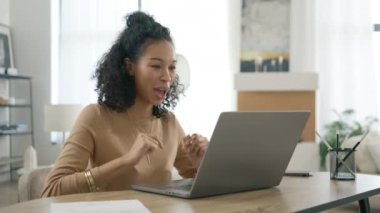 Farklı kıvırcık saçlı kadının portresi dizüstü bilgisayara bakıyor ve kamera 4K ile konuşuyor. Smiley çok ırklı kız girişimci. Partner ya da iş arkadaşlarıyla görüntülü iletişim kuruyor.