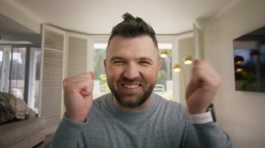 Aşırı neşeli, şık bir adam. Küçük bir çocuk gibi ellerini sallıyor. Kulaktan kulağa gülümsüyor. Süper olumlu gülüşü olan komik adam iyi haberler aldığına sevindi.