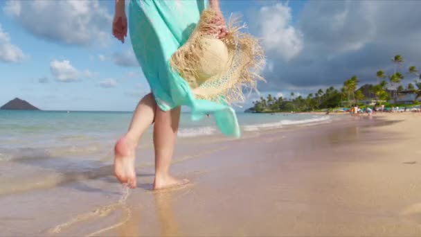 夏威夷的兰尼凯海滩女人穿着漂亮的飘飘然的长袍 戴着草帽 慢慢移动的女人脚赤脚在金色落日的阳光下走在沙滩上 在沙滩上留下脚印 暑假女游客 — 图库视频影像