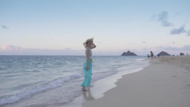 在蓝沙滩上快乐的旅行者戴着草帽 与纳莫库鲁阿岛一起欣赏在兰尼凯海滩上的电影海滩 热带天堂夏威夷岛 日落后走在异国情调海滩上的年轻女子4K — 图库视频影像