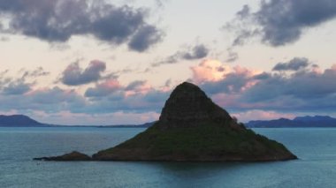 Açık hava macera konsepti. Oahu adasındaki manzara Hawaii simgesi. Çinlilerin Şapka piramit silueti pembe günbatımı bulutlarında. Kaneohe Körfezi 'ndeki Mokolii Adası. Kualoa Çiftliği Sinematik Seyahat Yeri