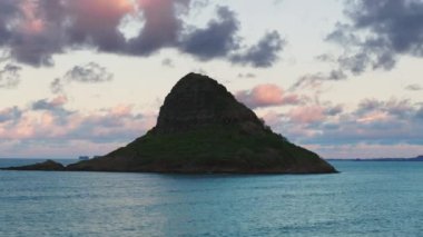 Sinematik seyahat, açık hava macera konsepti. Oahu adasındaki manzara Hawaii simgesi. Çinlilerin Şapka piramit silueti pembe günbatımı bulutlarında. Kaneohe Körfezi 'ndeki Mokolii Adası, Kualoa Çiftliği