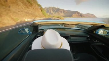 Açık hava macerası yaz tatili. Üstü açık modern araba arka koltukları manzaralı okyanus kıyısında araba süren şık bir genç kadın. Cabriolet 'teki egzotik Hawaii adasını çatısız gezen mutlu gezgin.